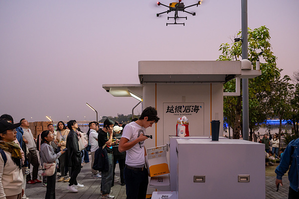 在深圳，外國(guó)游客體驗(yàn)無(wú)人機(jī)外賣送餐。