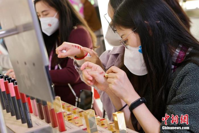 圖為女生正在體驗口紅產(chǎn)品。 殷立勤 攝