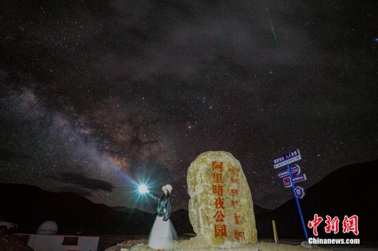 圖為6月20日晚，游客“打卡”西藏阿里暗夜公園，天上是銀河與流星（右上角）。曹枝清 攝