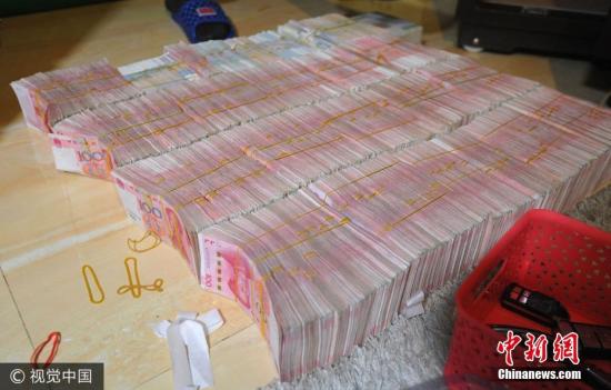 廣西南寧警方8月21日通報(bào),當(dāng)?shù)亟粘晒善粕姘附痤~15.19億元人民幣的特大傳銷案件。圖為當(dāng)場繳獲的成捆現(xiàn)金。圖片來源:視覺中國
