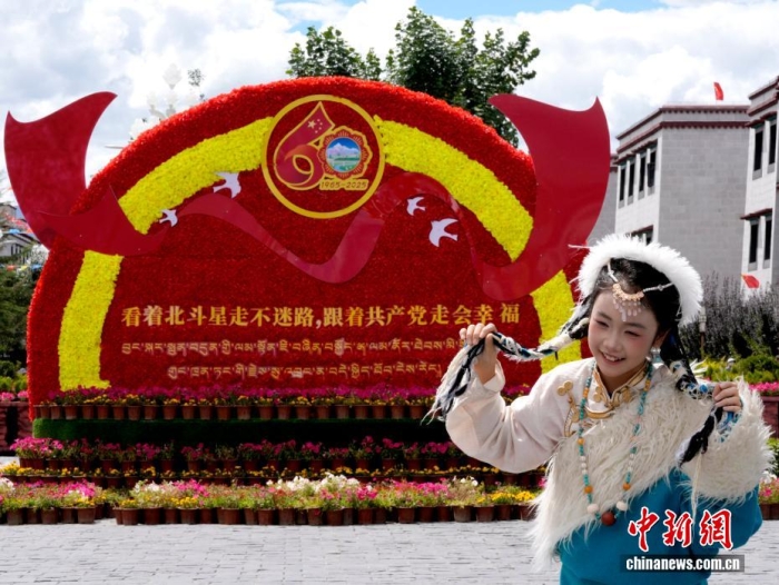 8月19日，隨著西藏自治區(qū)成立60周年慶?；顒?dòng)臨近，拉薩氛圍濃。拉薩街頭，處處是張燈結(jié)彩的盛景，洋溢著一派祥和與歡騰的氛圍。圖為游客在拉薩大昭寺廣場(chǎng)上的大慶宣傳標(biāo)語前留念。<a target='_blank' href='/'>中新社</a>記者 李林 攝
